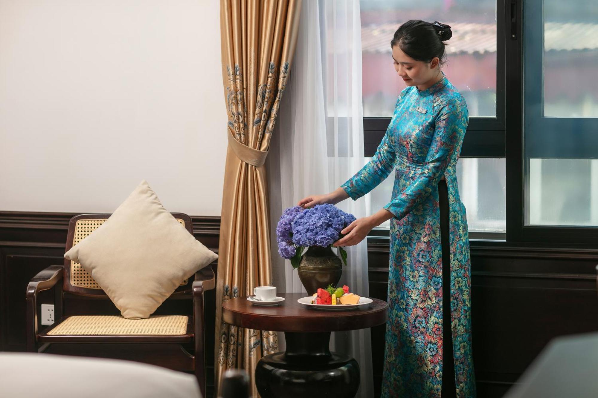 May De Ville Crown Hotel هانوي المظهر الخارجي الصورة A Vietnamese woman wearing an áo dài