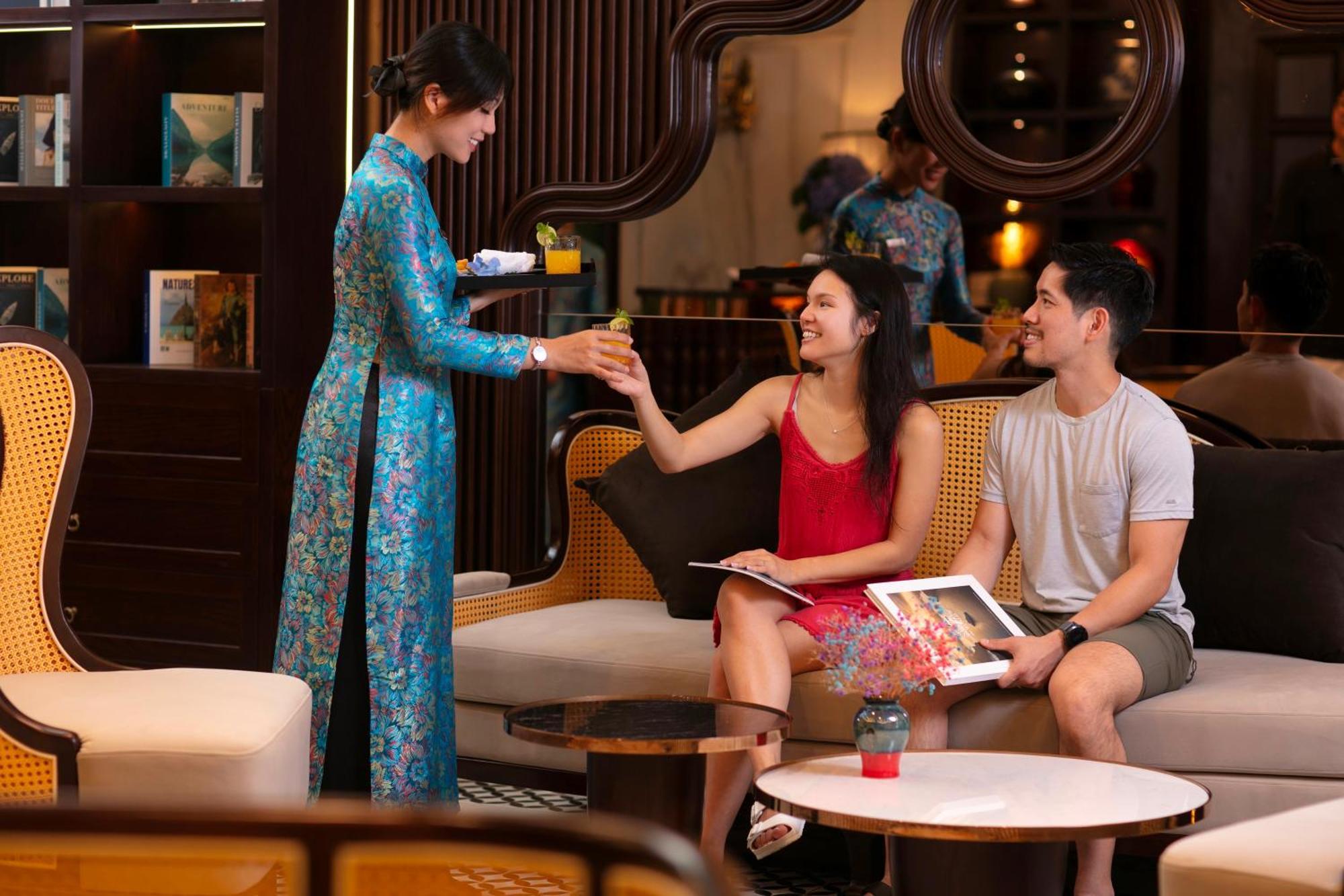 May De Ville Crown Hotel هانوي المظهر الخارجي الصورة A Vietnamese woman wearing an áo dài